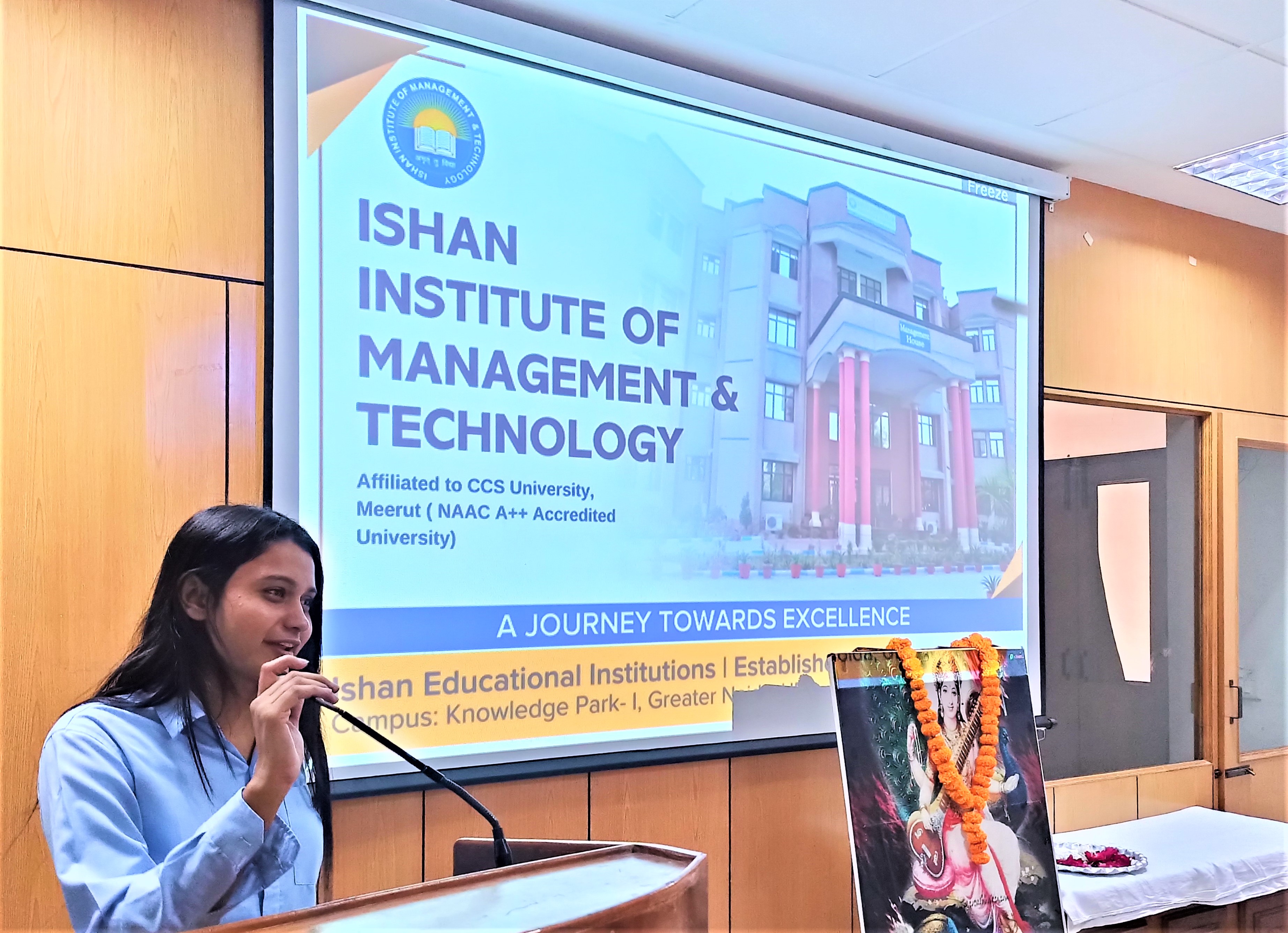 Ishan IIMT M Com student confidently delivering speech during academic session.
